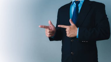 Reklam, ürün ve hizmet reklamları, pazarlama stratejisinde ürün seçimi veya gösterimini belirtmek için parmakları yana doğru duran bir işadamı.