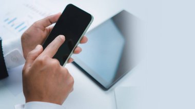 Ofis masasında cep telefonu kullanan bir kadın. İnternette sörf yapan iş kadını, akıllı telefondan bilgi arayan, internetten serbest çalışan, akıllı telefon kullanan, internette gezinen, uzaktan kumandalı...