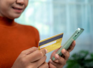 Çevrimiçi bankacılık işlem konsepti, kredi kartı kullanan mutlu kadın akıllı telefon ve online alışveriş, ticaret ve güvenli cep telefonu bankacılığı konsepti, çevrimiçi ödemeler.