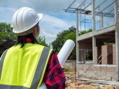 Projeyi elinde tutan mühendisler açık havada bir inşaat alanı, mühendislik ve mimari konsepti üzerine planları olan büyük bir inşaat projesinin şantiyesinde çalışan mühendis..