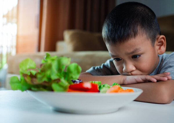 Little cute boy refuses to eat healthy vegetables, Children do not like to eat vegetables, Nutrition healthy eating habits for kids concept, Children do not like to eat vegetables.