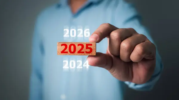 İş adamı elinde 2025 tahta blok, Risk ticareti ve yeni yıl kavramları, 2025 hedef planlama, geri sayım, 2025 iş planlaması, Çözüm, Strateji, Çözüm, Hedef.