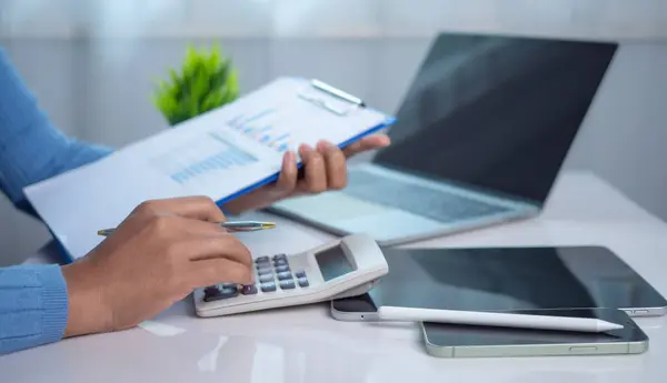 İş kadını el yazısı, maliyet, hesap makinesi ve bilgisayarla ilgili finansman ile sabah ışığında masada tablet, iş muhasebe konsepti, bakiye hesaplama veya denetleme gibi konularda çalışıyor..