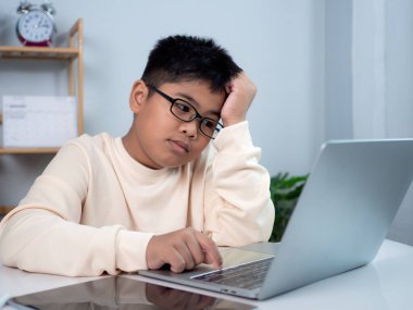 Bilgisayarı öğrenmek için kullanan ve çevrimiçi öğrenme, uzaktan eğitim, evde eğitim ve çevrimiçi eğitim konsepti ile okul öğretmeninden sanal internet dersi hakkında vurgulayan çocuk.