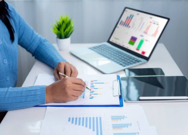 İş kadını, kurumsal verileri analiz etmek ve yönetmek için kağıt belgeler, KPI 'lerle iş analizleri, organizasyonel performans, pazarlama ve mali stratejiyi geliştirmek için KPI' ler gösteriyor.