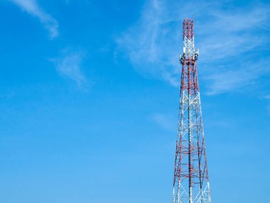 Vücuduna çeşitli anten türleri yerleştirilmiş bir telekomünikasyon kulesi, mavi gökyüzü arka planında hücresel iletişimden sorumlu yüksek anten kulesi.