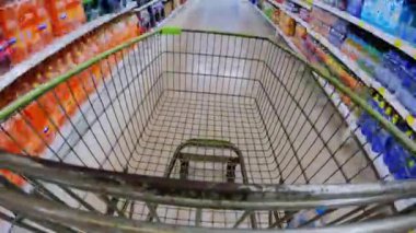 Alışveriş arabasının süpermarketten ya da alışveriş merkezinden geçişi. 4K 'da yakın çekim, UHD