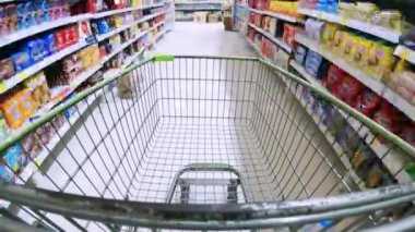Alışveriş arabasının süpermarketten ya da alışveriş merkezinden geçişi. 4K 'da yakın çekim, UHD
