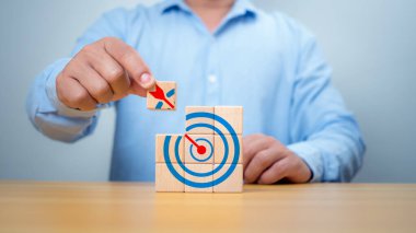 İşadamı elleri hedef tabelasıyla tahta blokları tamamlıyor. Başlangıç konsepti. İş konsepti. Yönetim konsepti. İş planlama kavramı.