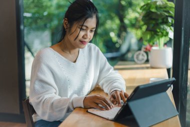 Ofis dışındaki projenin finansmanını analiz etmek için tablet üzerinde yeni bir girişim üzerinde çalışan iş kadınları, yurt içi ofisinde tablet kullanarak çalışan kadınlar, iş kadını tablet kullanma.