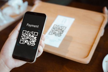 El, QR kodunu taramak için cep telefonu uygulaması, cep telefonu tutan eller, QR kod ödemesi veya nakitsiz teknoloji konsepti, parasız dijital ödemeyi kabul eden kahve dükkanı, anlamsız QR kodu.. 