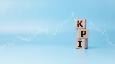 İşletme ve KPI 'nin organizasyon performansını artırmak için yaptığı göstergeler, mavi arka plan, pazarlama, şirket finans stratejileri, başarı göstergesi üzerine KPI kısaltması basılan tahta bloklar.
