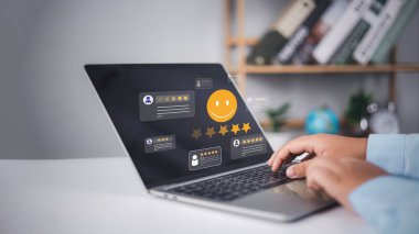 Memnuniyet anketi, müşteriler beş yıldızlı tecrübelerini değerlendirmek için dizüstü bilgisayar kullanırlar, hizmet kalitesinde iş itibarı sıralamaları, mutlu gülümseme simgeleriyle online başvuru hizmetleri, geri bildirim.