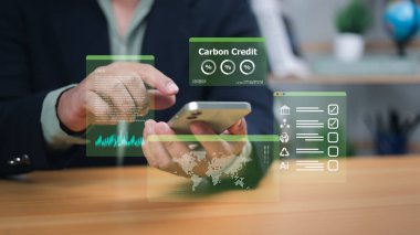 Eller holografik telefon arayüzü ile etkileşime girer ve karbon kredi, veri ve yapay zekayı gösterir. Dijital finansmanı, sürdürülebilir yatırımı ve teknoloji güdümlü gelecek için çevresel çözümleri simgeliyor..