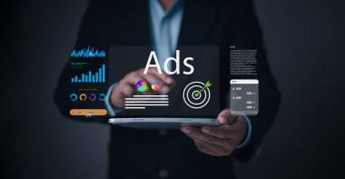 Bir işadamı hedefli reklamlar, renkli pazarlama grafikleri, performans analizleri ve dijital pazarlama ve çevrimiçi kampanya stratejisi için reklam paneli UI ile etkileşime girer