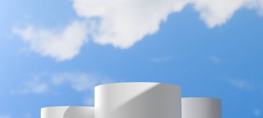 Değişen yüksekliklerden oluşan beyaz silindirik podyumlar yumuşak bulutlu açık mavi bir gökyüzüne karşı kurulmuştur. Minimalist açık hava sahnesi, temiz ve geniş bir zemin sunar, ürünlerin açık hava temalarını gösterir.