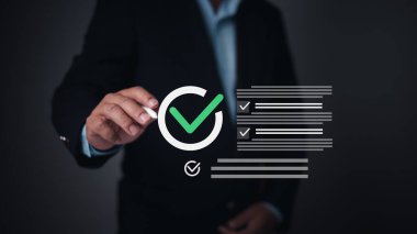 Person marks a holographic checklist with checkmark, symbolizing task completion, project success, quality control, and approval processes. Business, productivity, compliance, and achievement visuals.