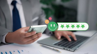 Pozitif müşteri deneyimi, hizmet kalitesi ve iş tatmini kavramı. İş adamı akıllı telefondan mutlu emojiyle beş yıldız puanı veriyor..