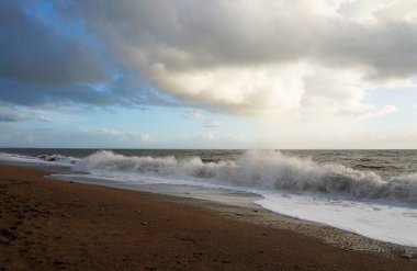 Kumsalda bulutlar, büyük dalgalar. Chesil Sahili 