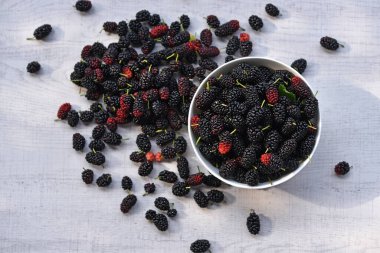 Ahşap arka planda dut kasesinin en üst görüntüsü.