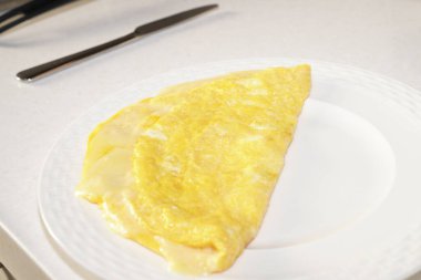 Beyaz tabakta peynirli omlet. Evde kahvaltı..