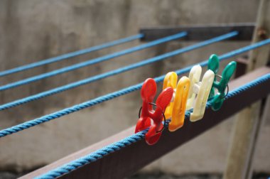 Askılarda renkli mandal mandalları var. Farklı renklerde plastik mandallar..                                                              