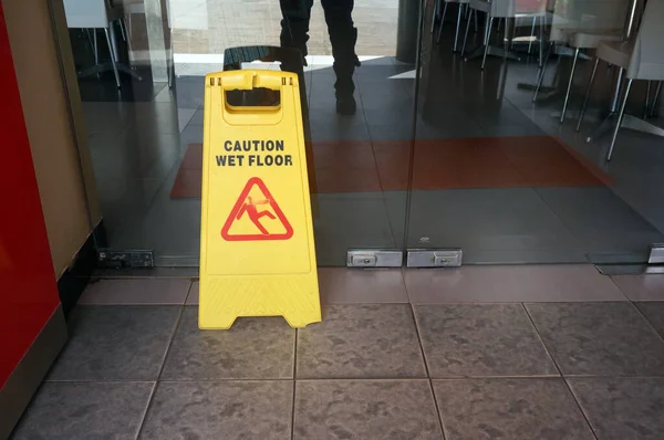 Caution  wet floor sign on floor in restaurant.