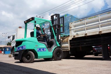 Sangatta, Doğu Kalimantan / Endonezya - 03 Ağustos 2020: yük paleti yükleyen forklift sürücüsü Perking bölgesi deposunda bir kamyon vinci ile.                               