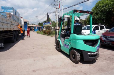 Sangatta, Doğu Kalimantan / Endonezya - 03 Ağustos 2020: yük paleti yükleyen forklift sürücüsü Perking bölgesi deposunda bir kamyon vinci ile.                                