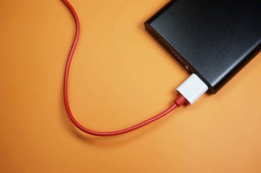 Kırmızı kabloyla turuncu arkaplanda elektrik faturaları                                                             