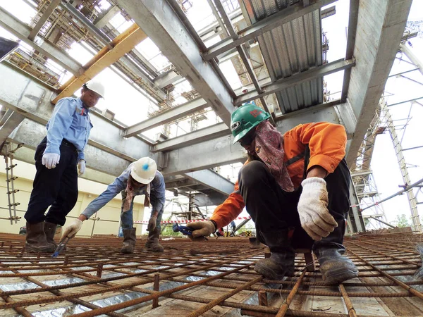 stock image Sangatta, East Kalimantan/Indonesia - September 2017: Worker connects fittings wire on conveyor and crusher building construction. 