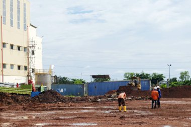 Sangatta, Kutai Timur, Doğu Borneo, Endonezya. 06/07/2017. Kömür Ateşli Enerji Santrali Projesi. Kamu çalışanları toprağı topluyor..