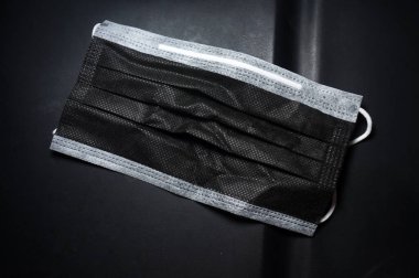 Siyah cerrahi maske siyah arkaplanda izole edildi                                                            