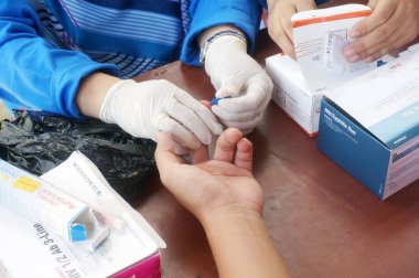 Doğu Kutai, Doğu Kalimantan, Endonezya - 08 Ağustos 2022: Bir sağlık çalışanı HIV, Seçici Odak için parmak batırma testi uygular                         