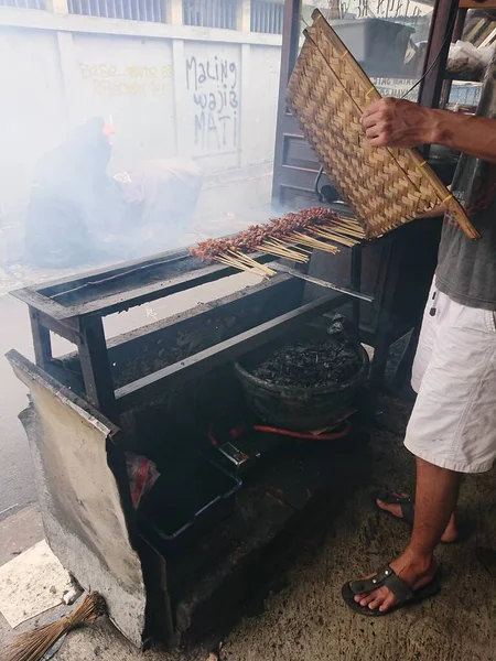 Zbliżenie Człowiek Palenie Kurczaka Satay Lub Satay — Zdjęcie stockowe
