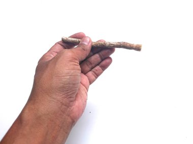 Erkek eli, siwak ya da miswak, eski geleneksel diş fırçası ve diş macunu beyaz arka planda