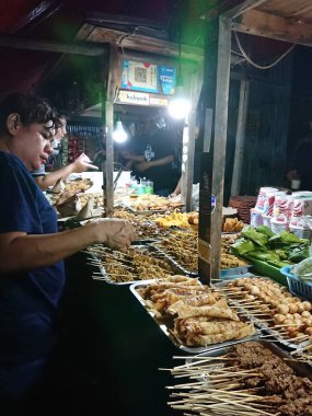 Satıcı ve alıcı Nasi Kucing veya Angkringan, abur cubur, gorengan, Yogyakarta 'da küçük boy gece yemeği