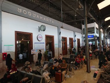 fotoğraf editörü, yogyakarta, yogya, jogja, jogjakarta, endonezya, merkez java, büyük asılı beyaz saat ve tren istasyonu işareti arasında hareket, bazı yolcular görüldü