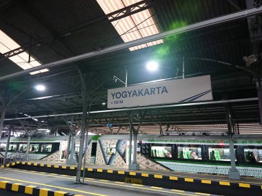 fotoğraf editörü, yogyakarta, yogya, jogja, jogjakarta, endonezya, merkez java, büyük asılı beyaz saat ve tren istasyonu işareti arasında hareket, bazı yolcular görüldü