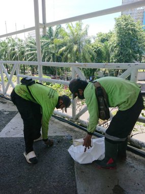 Yayın fotoğrafı, Endonezya, 29 Kasım, köprünün karşısındaki çöpleri temizleyen adamlar, işlerini yapıyorlar. 