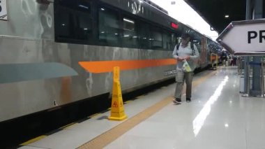 footage editorial, 05 November 2022, yogyakarta, yogya, jogja or jogjakarta indonesia railroad crossing, some people and train passing by 