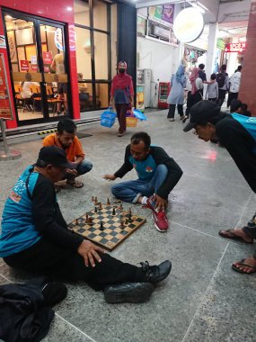 photo editorial, 07 november, 3 man playing chess at malioboro, yogya, jogja, jogjakarta, indonesia