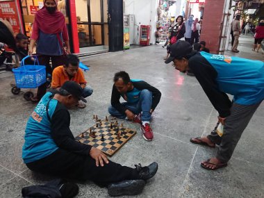 photo editorial, 07 november, 3 man playing chess at malioboro, yogya, jogja, jogjakarta, indonesia