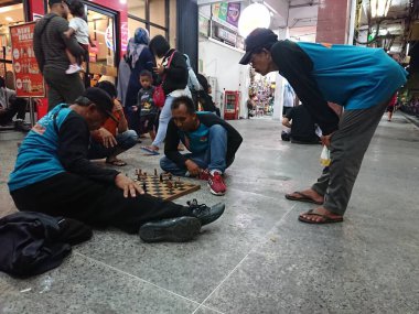 photo editorial, 07 november, 3 man playing chess at malioboro, yogya, jogja, jogjakarta, indonesia