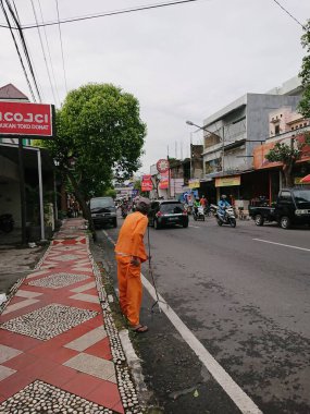 photo editorial, 29 december 2022, indonesia, using crutches walking old parking officer at side walk
