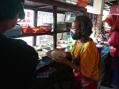 photo editorial, 29 december 2022, indonesia buyer and seller traditional food small restaurant, ngasem market, yogyakarta, indonesia
