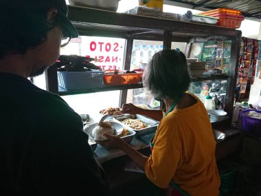 photo editorial, 29 december 2022, indonesia buyer and seller traditional food small restaurant, ngasem market, yogyakarta, indonesia