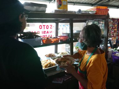 photo editorial, 29 december 2022, indonesia buyer and seller traditional food small restaurant, ngasem market, yogyakarta, indonesia