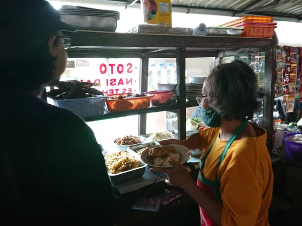 photo editorial, 29 december 2022, indonesia buyer and seller traditional food small restaurant, ngasem market, yogyakarta, indonesia