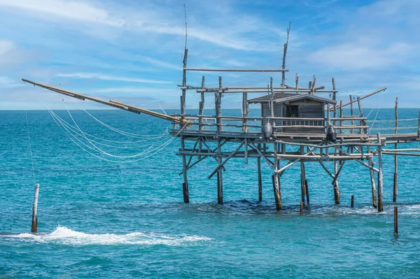 San Vito Chietino - 07-08-2022: Kristal berrak ve mavi denizi ve arka planda trabocco ile Calata Turchina 'nın güzel plajı